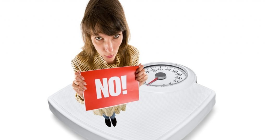 Woman on scales with word, 'NO'. NSV to be monitored