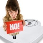 Woman on scales with word, 'NO'. NSV to be monitored